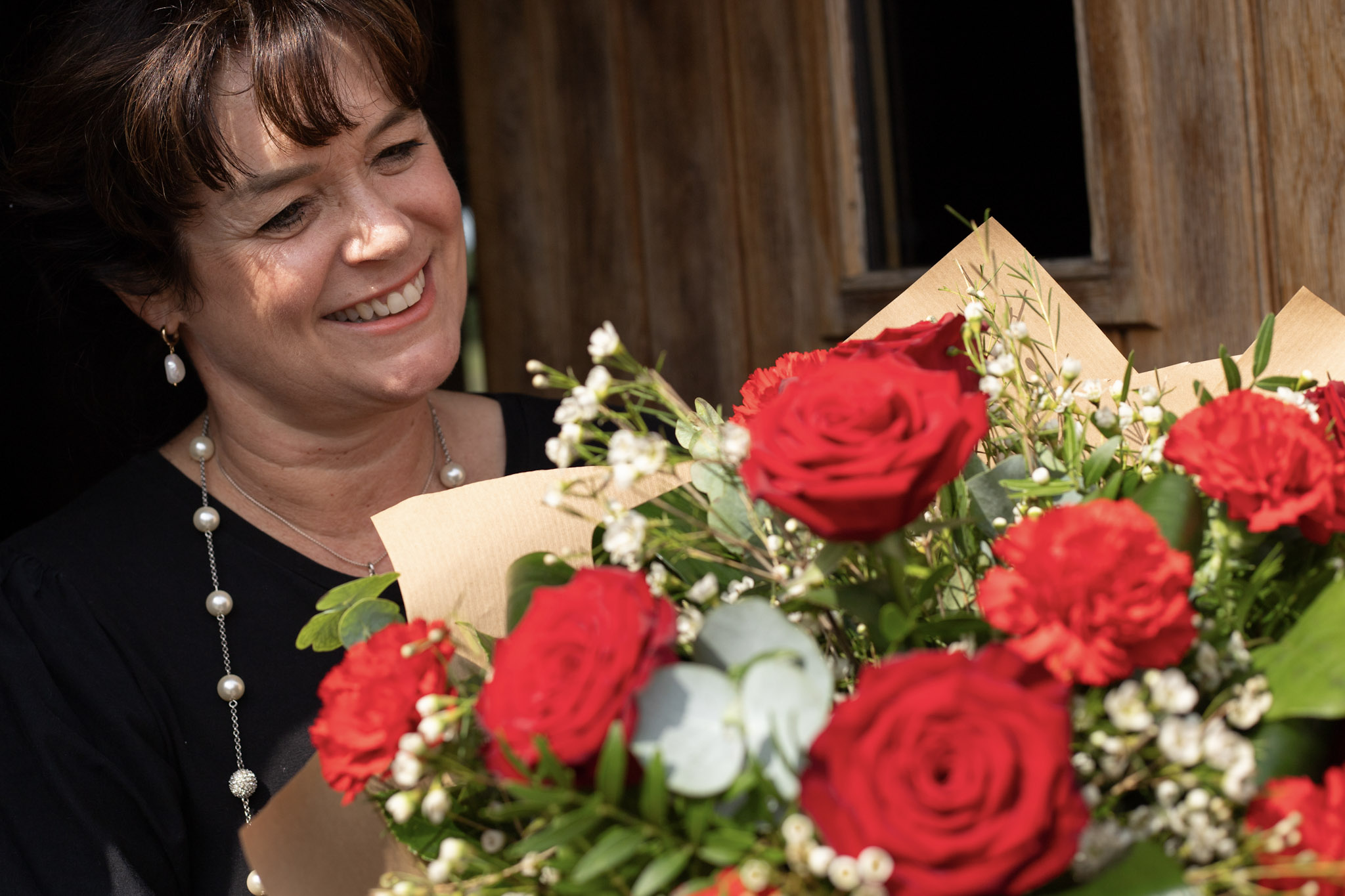 Woman receiving red roses from local florist with same day delivery in Ireland